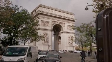 Paris, Fransa. 27 Ekim 2023. Paris 'teki yemyeşil ağaçlar ve hareketli araçlarla çevrili tarihi Zafer Takı' nın çarpıcı manzarası.