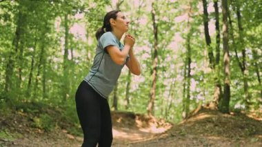 Bir kadın, sağlıklı bir yaşam tarzını geliştirmek için doğayla uygunluğu ustalıkla birleştirerek açık hava egzersizine girişir.