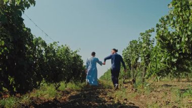 Bir çift, doğal bir üzüm bağında romantik bir anı paylaşıyor, doğayı kucaklıyor ve birbirlerine olan sevgilerini paylaşıyor.