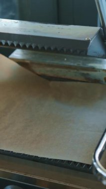 Lezzetli bir sosisli sandviç ustalıkla ızgara ediliyor, şık bir mutfakta pişirme sürecinin altını çiziyor.