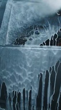 Bu, yıkama sırasında iyice köpüren bir arabanın detaylı temizlik sürecini gösteren yakın çekim görüntüsü.