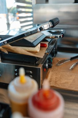 Canlı bir yemek hazırlama sahnesi ızgara aletleri ve rengarenk baharatlar düzgünce düzenlenmiş ve servis için hazır.