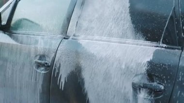 Canlı köpük ve yüksek basınçlı su püskürten araba yıkama makinesinin dinamik görselleri.