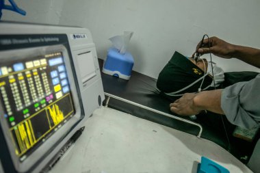 BOGOR, INDONESIA - 27 Mart 2023: Bir vatandaş 27 Mart 2023 tarihinde Endonezya 'nın Bogor Regency District, Ainun Cahaya Medika göz kliniğinde bir biyometri cihazı kullanarak bir göz testi gerçekleştirdi.