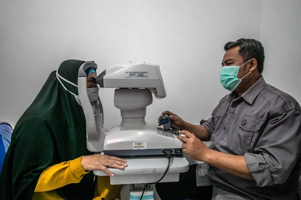 BOGOR, INDONESIA - 27 Mart 2023: Endonezya 'nın Bogor Regency Bölgesi, Ainun Cahaya Medika göz kliniğinde bir özel mikroskop kullanan bir vatandaş, 27 Mart 2023 tarihinde bir göz testi gerçekleştirdi.