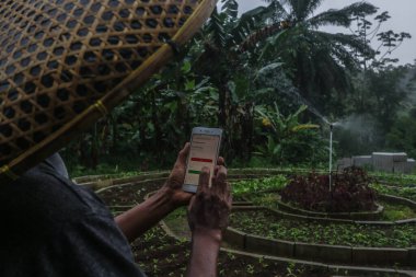 BOGOR, INDONESIA - 18 Şubat 2022: Bogor, Batı Java, Endonezya 'daki çiftçiler, tesislerini sulamak için teknolojiyi kullanıyorlar.