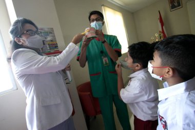 Bogor, Endonezya - 31 Temmuz 2023: Diş hekimleri, Endonezya 'daki Vania Bogor Hastanesi' ni ziyaret eden ilkokul öğrencilerine diş sağlığı ve diş sağlığının korunması konusunda eğitim sunuyor