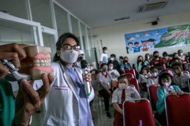 Bogor, Endonezya - 31 Temmuz 2023: Diş hekimleri, Endonezya 'daki Vania Bogor Hastanesi' ni ziyaret eden ilkokul öğrencilerine diş sağlığı ve diş sağlığının korunması konusunda eğitim sunuyor