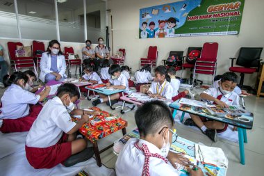 Bogor, Endonezya - 31 Temmuz 2023: Bogor City, Endonezya 'da ilköğretim öğrencileri, Vania Bogor Hastanesi' ni ziyaret ederken sağlık temalı resimlerde boyama faaliyetleri yürüttüler.