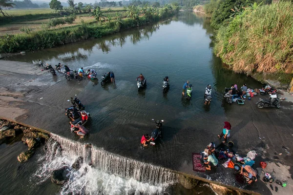 Bogor, Endonezya - 05 Ağustos 2023: Gunung Sari Köyü, Bogor Regency, West Java, Endonezya sakinlerinin faaliyetleri, Lulud Nehri 'nde çamaşır ve motosikletleri yıkamak, çünkü evlerindeki su kurak mevsim nedeniyle kurumuş.