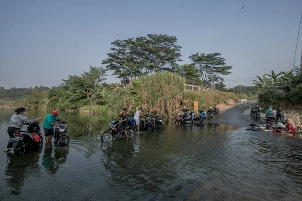 Bogor, Endonezya - 05 Ağustos 2023: Gunung Sari Köyü, Bogor Regency, West Java, Endonezya sakinlerinin faaliyetleri, Lulud Nehri 'nde çamaşır ve motosikletleri yıkamak, çünkü evlerindeki su kurak mevsim nedeniyle kurumuş.