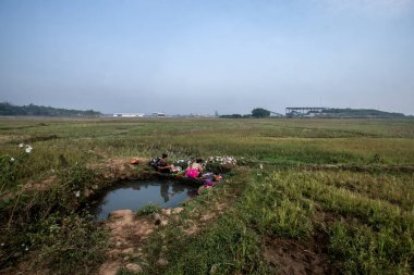 Bogor, Endonezya - 12 Ağustos 2023: Bogor, Batı Java sakinleri, kuraklığın neden olduğu temiz su sıkıntısı nedeniyle çeltik tarlasına sızma suyu kullanmak zorunda kaldı. 