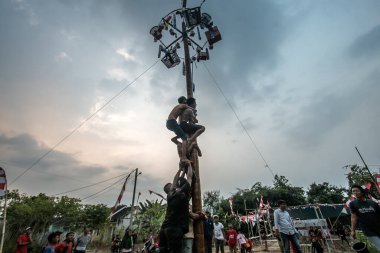 Bogor, Endonezya - 20 Ağustos 2023: Indonezya 'nın 78. Bağımsızlık Günü' nde Bogor, Batı Java 'da asılı kalan ürünler için bagajı yağlayıcı sıvıyla kaplanmış bir betel fıstığına tırmanmak için yarışan vatandaşlar