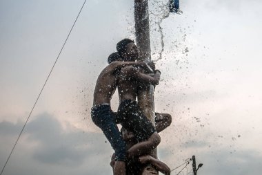 Bogor, Endonezya - 20 Ağustos 2023: Indonezya 'nın 78. Bağımsızlık Günü' nde Bogor, Batı Java 'da asılı kalan ürünler için bagajı yağlayıcı sıvıyla kaplanmış bir betel fıstığına tırmanmak için yarışan vatandaşlar