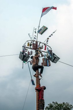 Bogor, Endonezya - 20 Ağustos 2023: Indonezya 'nın 78. Bağımsızlık Günü' nde Bogor, Batı Java 'da asılı kalan ürünler için bagajı yağlayıcı sıvıyla kaplanmış bir betel fıstığına tırmanmak için yarışan vatandaşlar