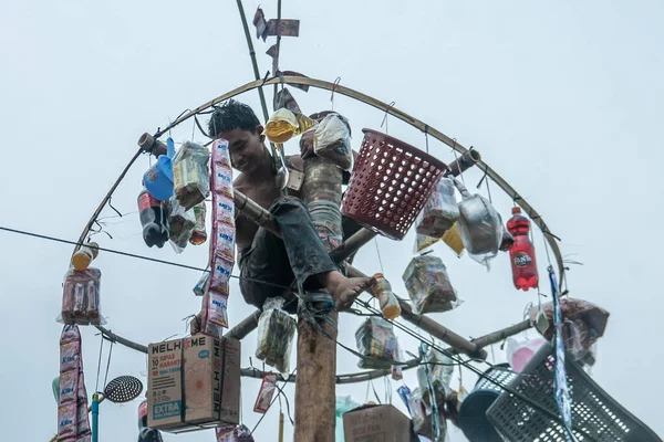Bogor, Endonezya - 20 Ağustos 2023: Bir vatandaş, Endonezya 'nın 78. Bağımsızlık Günü' nü kutlamak için Bogor, Batı Java 'da düzenlenen bir betel fındık tırmanma yarışmasında zirveye ulaştı ve ödül kazandı.