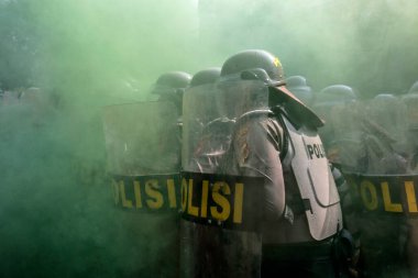 Bogor City, Batı Java, Endonezya 'da kask ve kalkan takan polis memurları, 2024 seçim güvenliği sırasında simülasyon göstericileriyle karşılaşmaya hazırlanıyorlar.. 