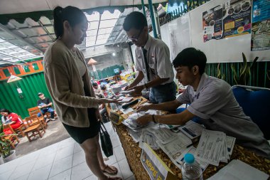 Endonezya 'nın Bogor kentinde yapılan 2024 genel seçimleri sırasında, bir sandık merkezinde lise üniforması giyen personel seçimleri yetkilileri, 14 Şubat 2024. 