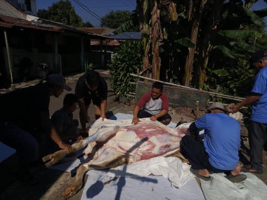 7 Haziran 2025 'te Bogor, Endonezya' da çok sayıda insan sığır eti kesiyor.