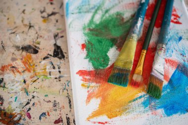 Resim dersleri, boyalı tuvaller, fırçalar ve resim için diğer elementler.