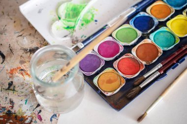 Resim dersleri, boyalı tuvaller, fırçalar ve resim için diğer elementler.