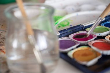 Resim dersleri, boyalı tuvaller, fırçalar ve resim için diğer elementler.