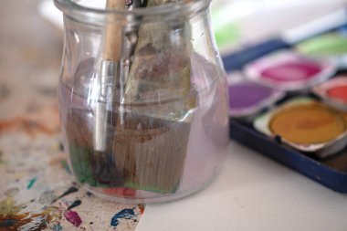 Resim dersleri, boyalı tuvaller, fırçalar ve resim için diğer elementler.