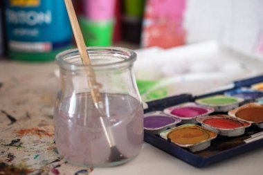 Resim dersleri, boyalı tuvaller, fırçalar ve resim için diğer elementler.