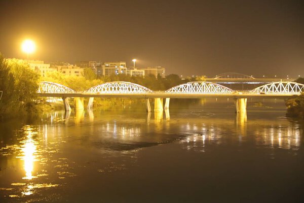 stone bridge with night illumination in the city of zaragoza, spain