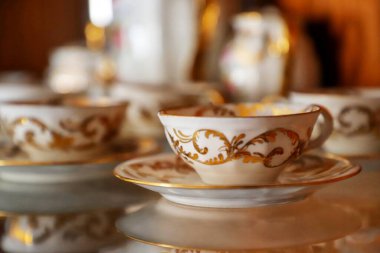 Bir fincan çay ve seramik çaydanlık ahşap bir masada.