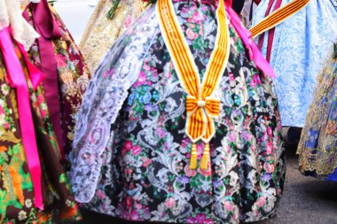 Bakire kadına sunulurken Falleras 'ın renkli elbiseleri.