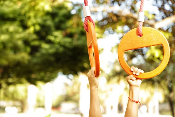 Kumsalda oyuncak bir uçurtma tutan bir kadının eli.