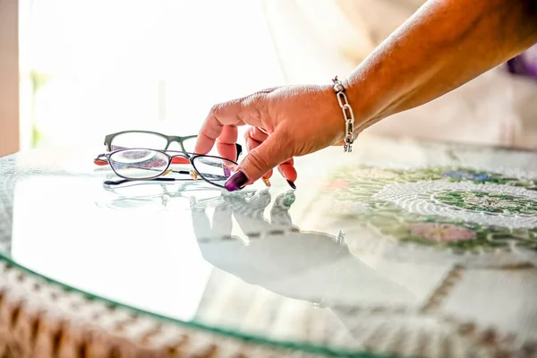 Hände Einer Frau Die Eine Brille Von Einem Tisch Aufhebt — Stockfoto