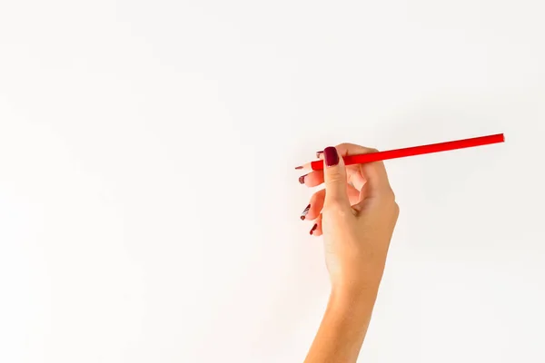 stock image hand of a young woman holding a red colored pencil, white background