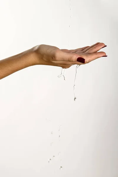 Mãos Uma Jovem Mulher Gotejando Água Clara Fundo Branco — Fotografia de Stock
