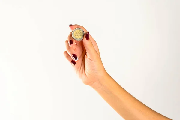 Stock image hands of a young woman holding a two euro coin, white background