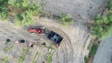 Üzüm hasadında üzüm kutularını toplayan traktörün hava görüntüsü.