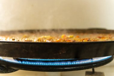 Paella tavasında geleneksel İspanyol paella 'sı pişiriyorum.