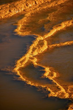 Sunset illuminates the terraced mineral pools, showcasing the vibrant geological layers at Rio Tinto