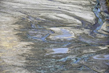 Naturally striated rock formations with traces of blue-green acidic water in the Rio Tinto region