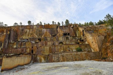 Decaying remains of mining structures stand over a stagnant water body at the Rio Tinto mines, a relic of industrial activity