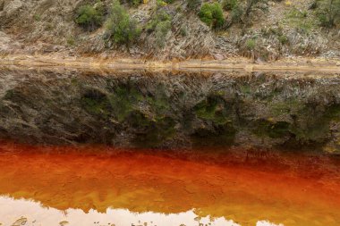 Toprağın çarpıcı katmanları ve Rio Tinto 'nun çatlak zemininde canlı bir kırmızı su çizgisi.