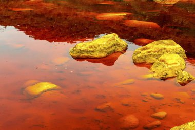 Toprağın çarpıcı katmanları ve Rio Tinto 'nun çatlak zemininde canlı bir kırmızı su çizgisi.