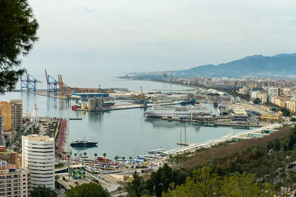 Wide-angle panorama of Puerto de Malaga, showcasing the bustling port, city architecture, and distant mountains