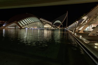 Sanat ve Bilim Şehri 'nin aydınlatılmış görüntüsü, gece gökyüzüne karşı modern tasarımı sergiliyor.