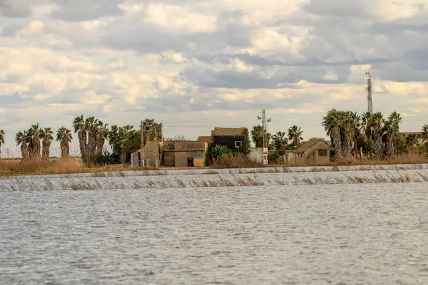 stock image A charming thatched-roof cottage stands by the waters edge in Albufera Natural Park near Valencia, offering a peaceful rural retreat.