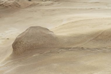Close-up of a smooth sandstone surface featuring gentle erosion patterns and subtle textures. Ideal for backgrounds, nature themes, and geological studies.