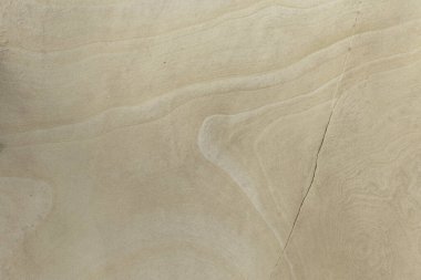 Close-up of a smooth sandstone surface featuring subtle natural patterns and textures. Perfect for backgrounds, nature themes, and geological studies.