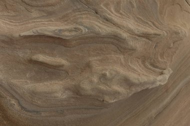 Close-up of intricate sandstone swirls and erosion patterns, highlighting the natural beauty and texture of sedimentary rock formations. Perfect for geological themes and backgrounds.