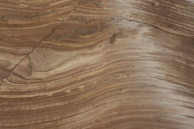 Close-up of intricate sandstone swirls and erosion patterns, highlighting the natural beauty and texture of sedimentary rock formations. Perfect for geological themes and backgrounds.